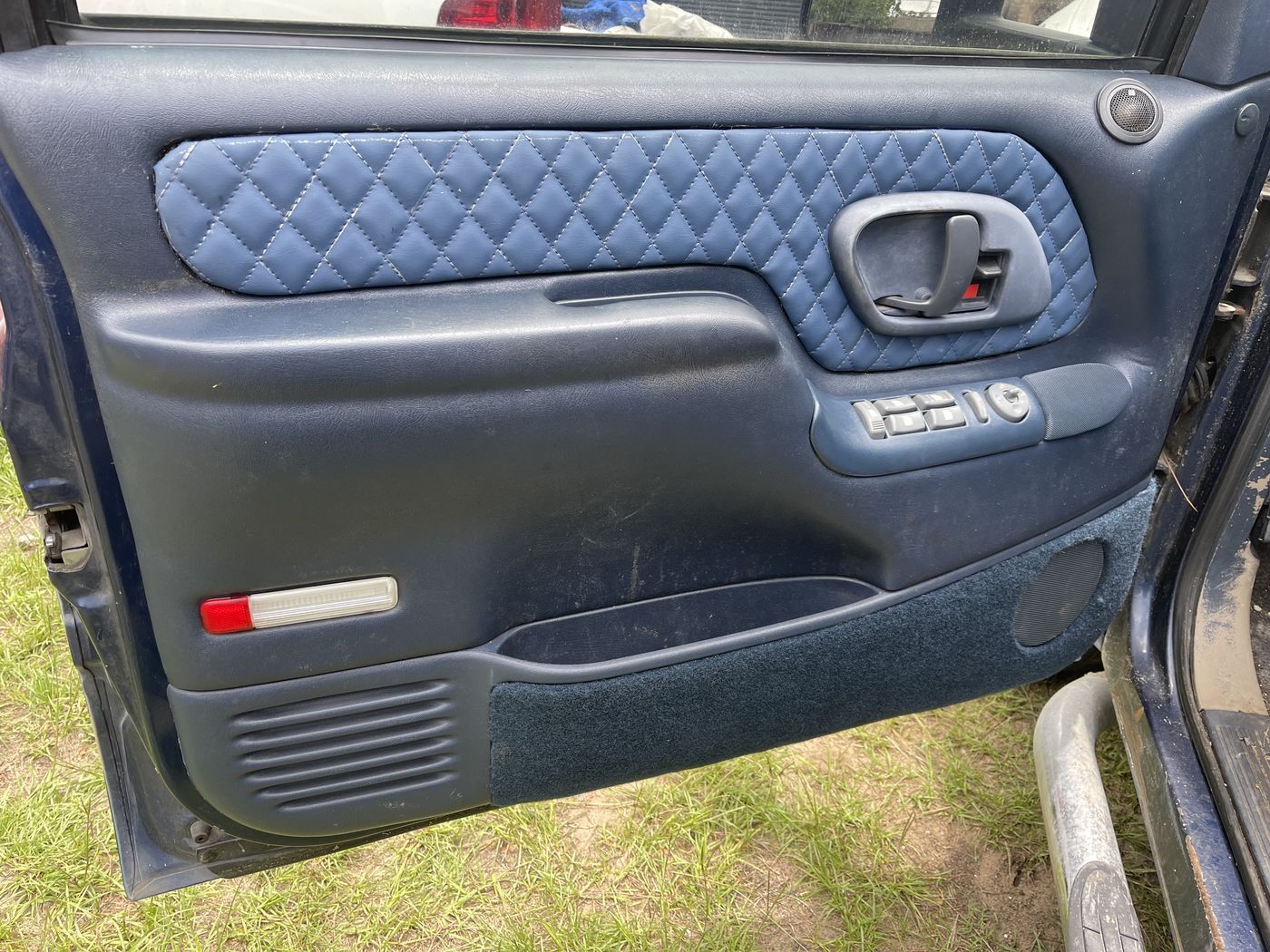 Black door panel with blue diamond stitching