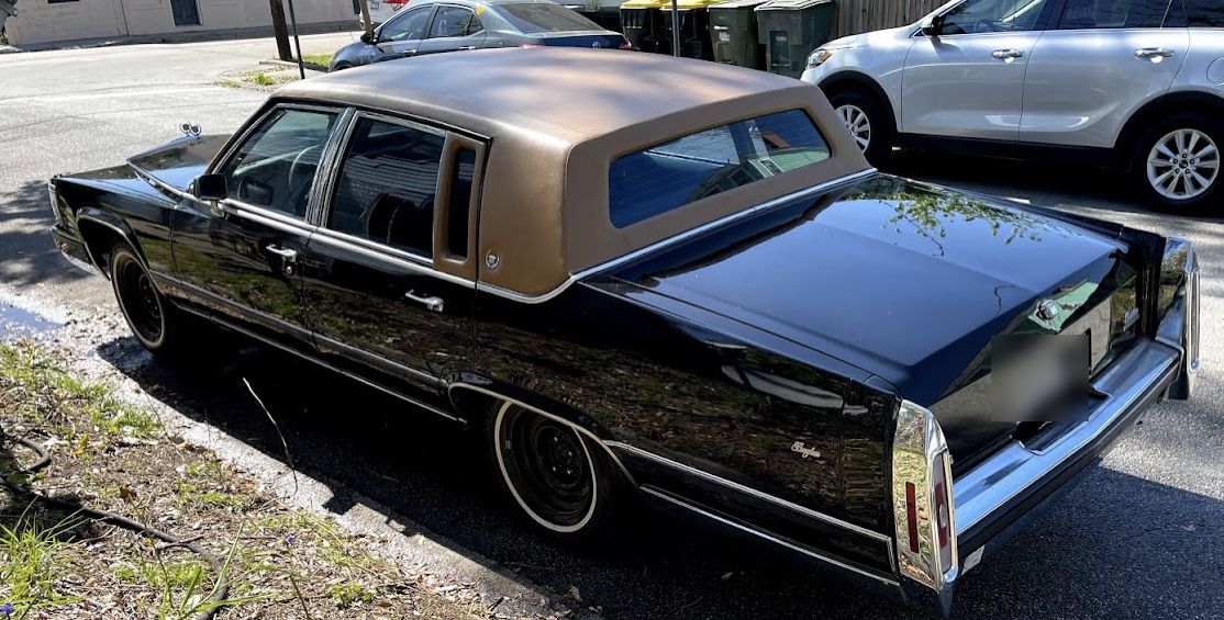 Black Cadillac with a gold landau top